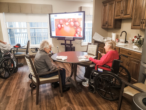 Seniors engaging in a group activity featuring interactive technology in a care facility.