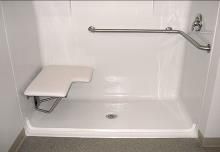 An accessible shower with a folding seat and safety bar.