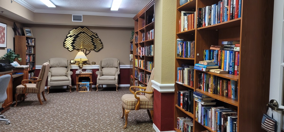 A cozy library with bookshelves filled with books and a comfortable reading area.