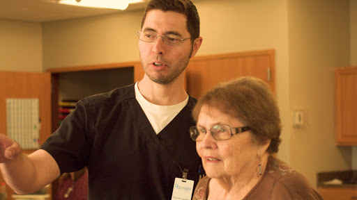 A healthcare professional interacts with an elderly woman, providing assistance and support.