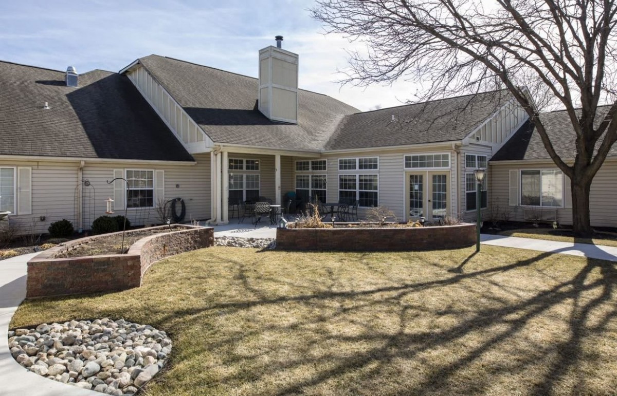 A view of a house with a spacious backyard and outdoor patio.