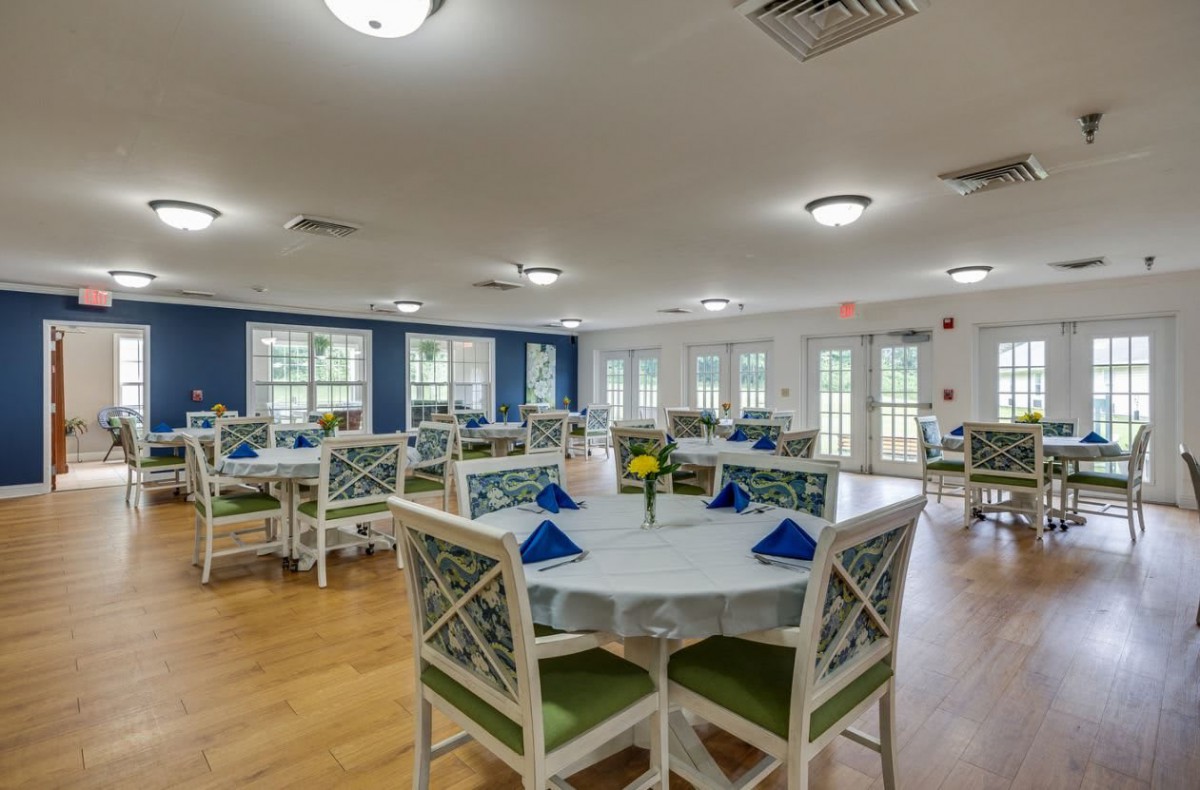 A bright and spacious dining room with neatly arranged tables and chairs.