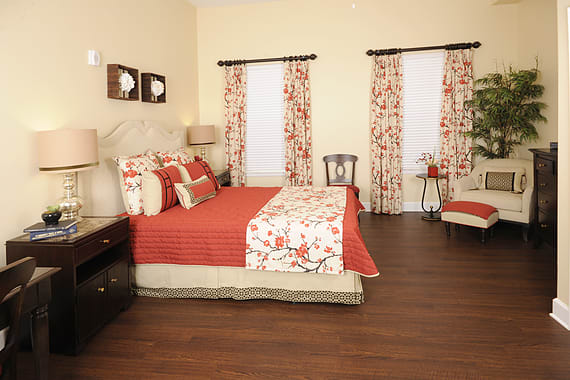 A cozy bedroom with floral decor and warm colors.