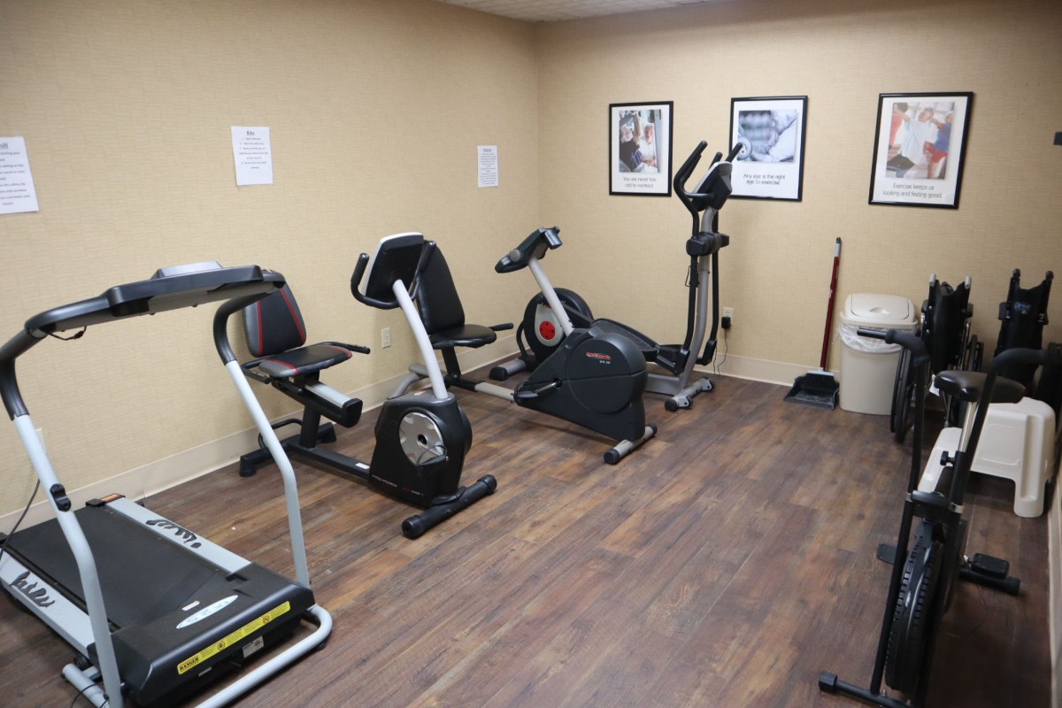 A small gym with various exercise equipment, including treadmills and stationary bikes.