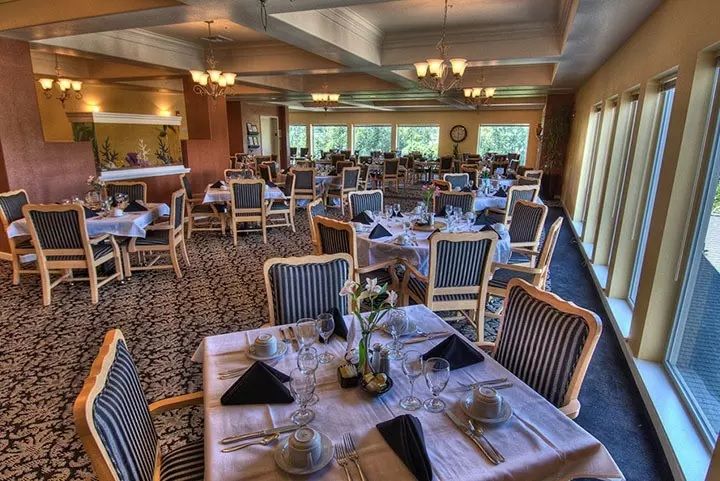 An elegantly set restaurant dining area with neatly arranged tables and chairs.
