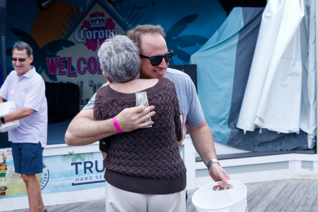 Two people hugging at an outdoor event.