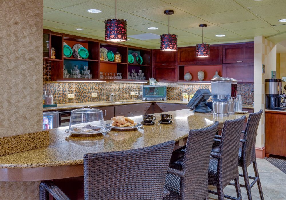 A well-appointed kitchen interior with a central counter, seating, and decorative shelving.