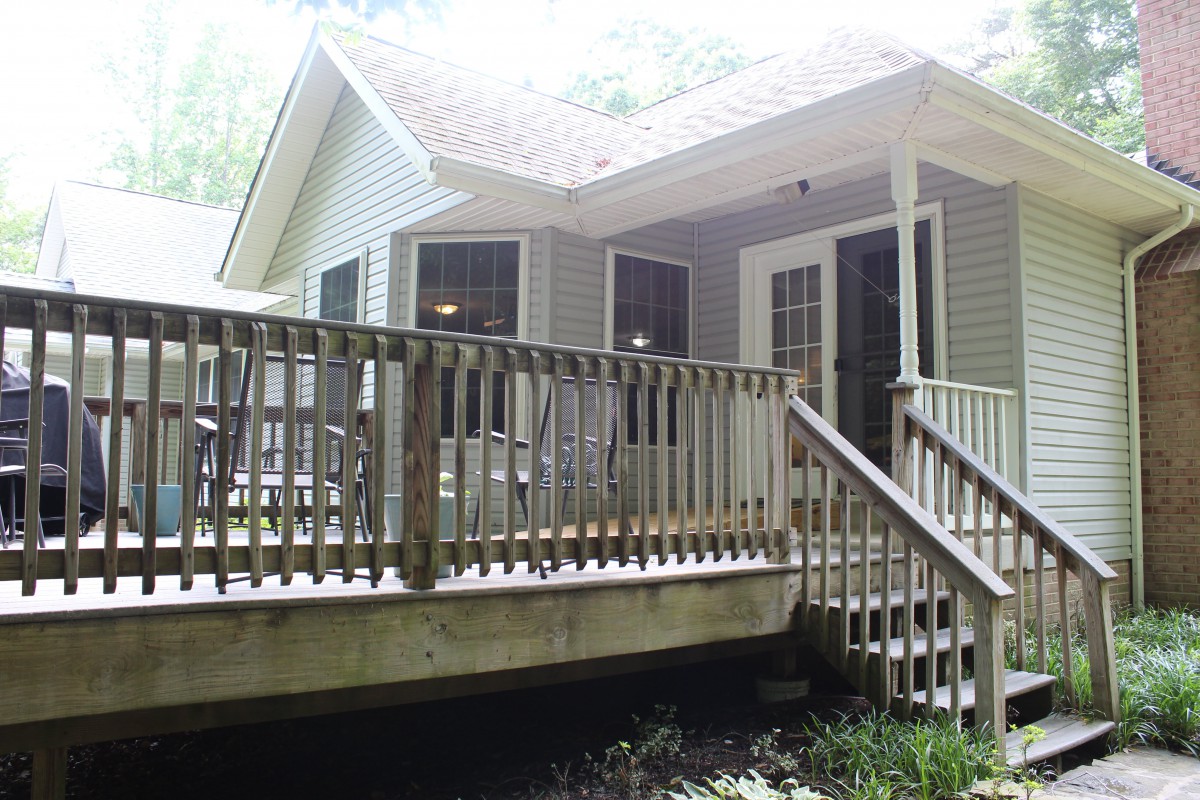 A cozy house with a wooden deck and stairs.