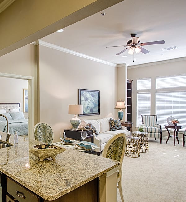 A modern open-plan living area with a kitchen island and natural lighting.