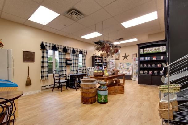 A rustic-themed store interior with wooden flooring, decorative barrels, and shelves displaying various items.