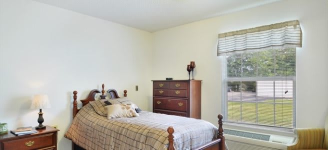 A cozy bedroom with a single bed and a dresser by the window.