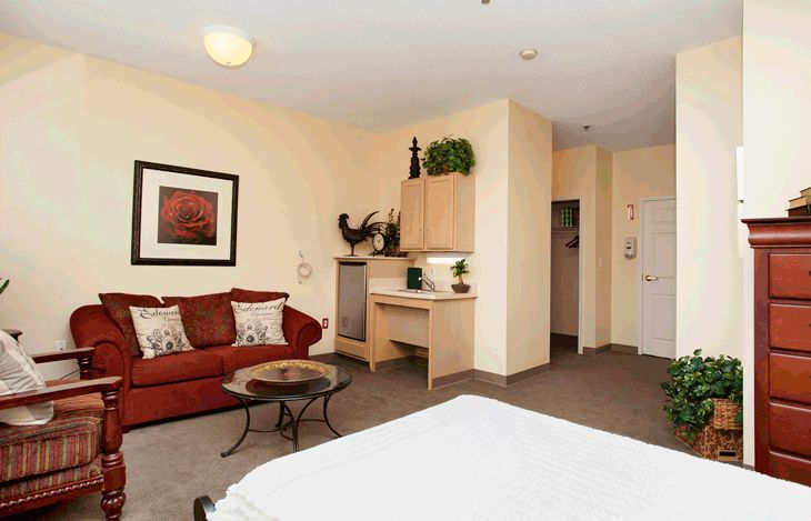 A hotel room with a comfortable sofa and a bed, featuring elegant decor.
