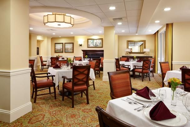 An elegant restaurant interior with neatly set tables and comfortable seating.