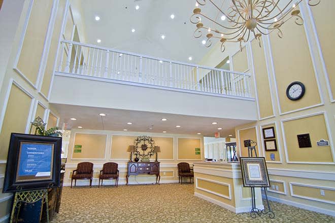 Spacious and well-lit lobby with a prominent chandelier and reception desk.