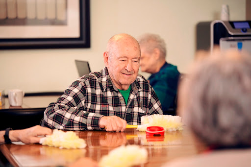 An elderly man enjoys a cheerful moment while participating in a group activity.