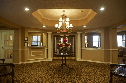 A luxurious lobby with a central table and chandelier.