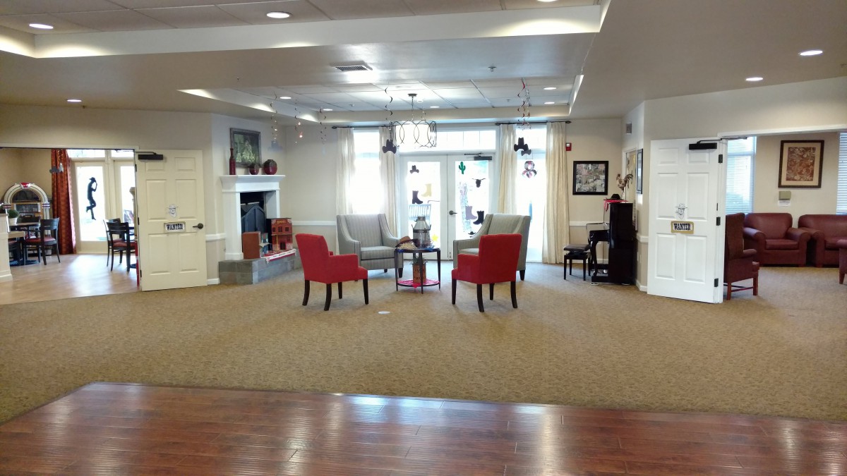 A cozy lobby area with red chairs and a fireplace.