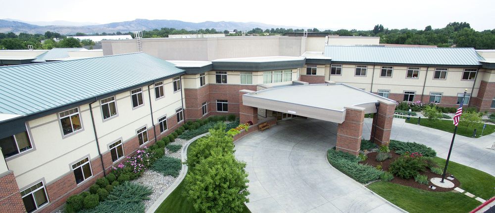 A modern building with landscaped greenery and a covered entrance.