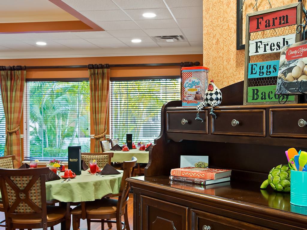 A cozy dining area with neatly arranged tables and a decorative sign in the foreground.