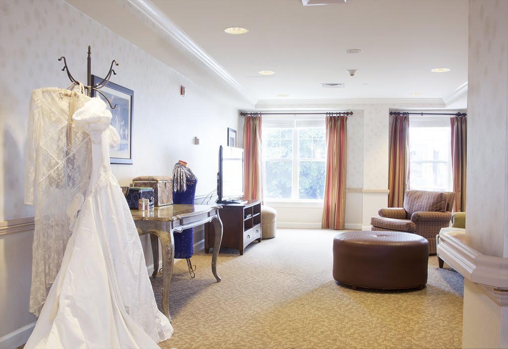 A cozy living room with a wedding dress on display.