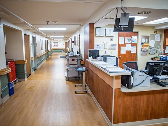 An empty hospital hallway with a nurse station.