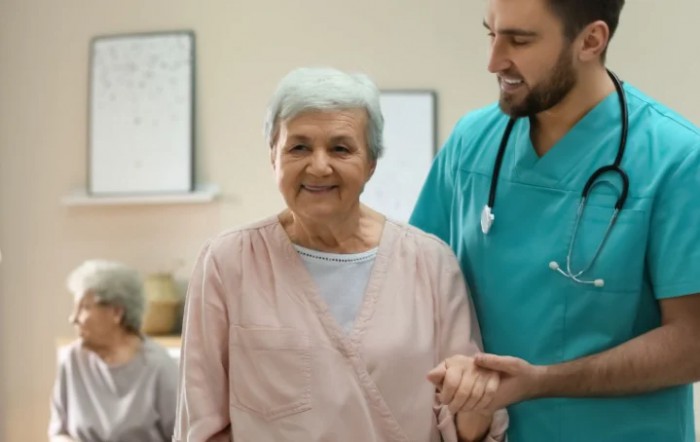 A nurse assists an elderly woman, offering support and care.