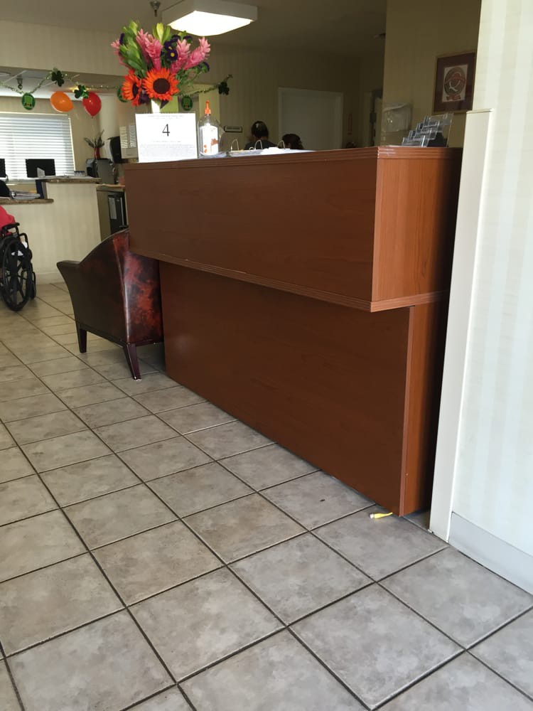 A reception area with a wooden desk and tiled floor.