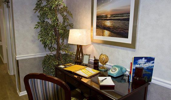 A cozy office corner with a desk, lamp, and vintage telephone.