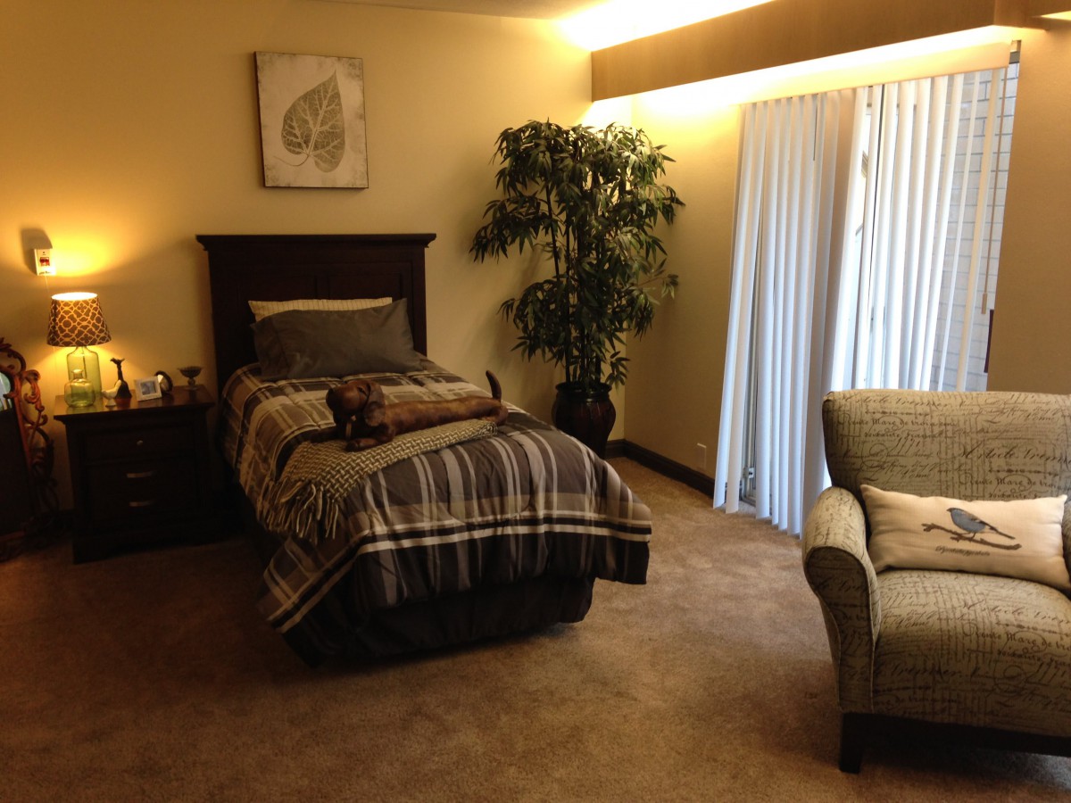 Cozy bedroom with a bed, armchair, and decorative elements.