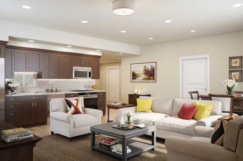 A modern living room with an open concept design featuring a sofa, coffee table, and adjacent kitchen.