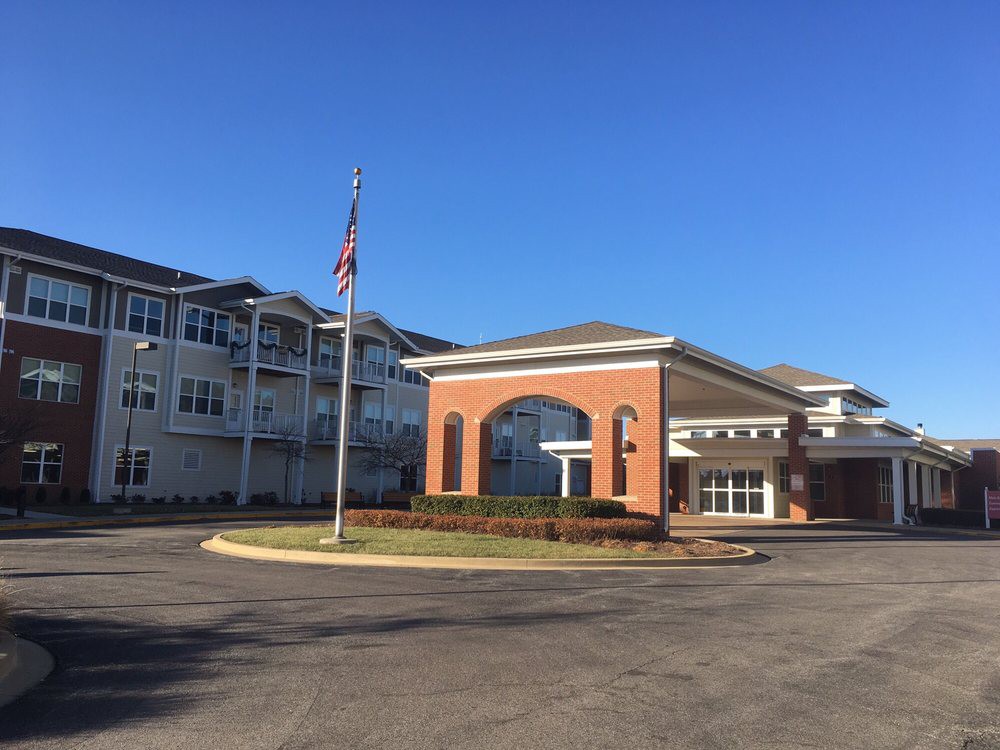 A modern building with an American flag at the entrance under a clear blue sky.