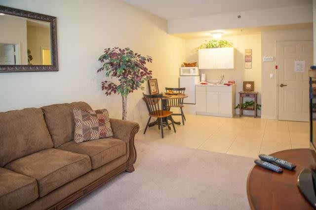 Cozy living area with a sofa and dining space, overlooking a compact kitchen.