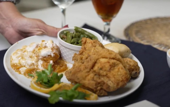A plate featuring fried chicken, green beans, a biscuit, and mashed potatoes with gravy.