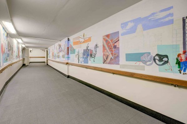 A long hallway featuring a colorful mural on the wall.