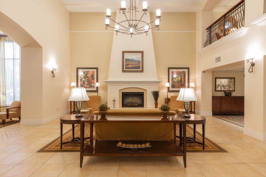 A beautifully designed living room featuring a fireplace, elegant chandelier, and tasteful artwork.