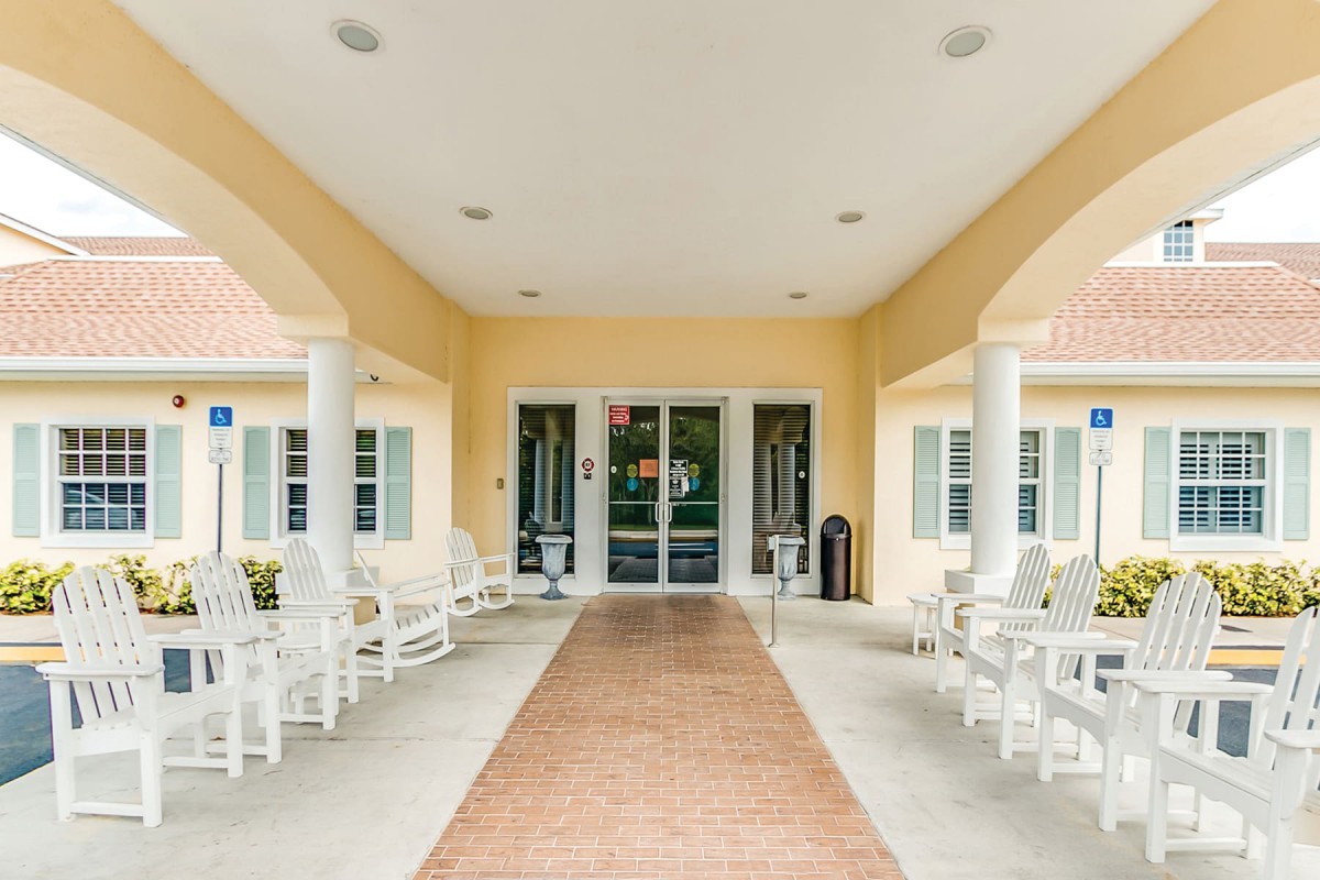 A welcoming building entrance with a covered porch and seating area.