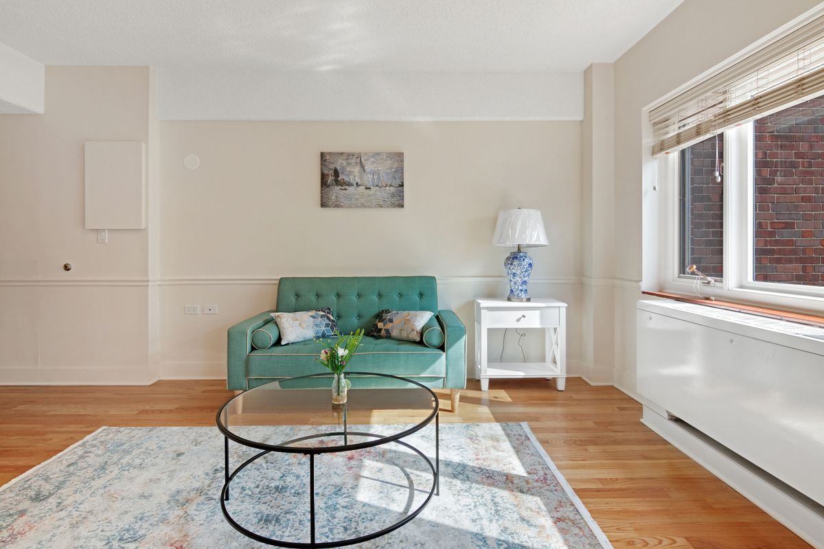 A cozy living room with a teal sofa, coffee table, and decorative elements.