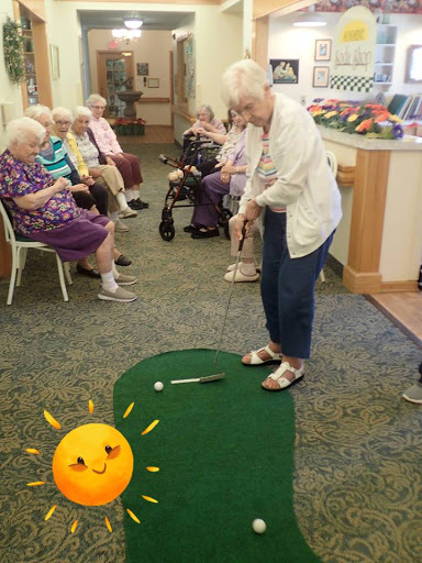 Seniors enjoying a lively indoor mini-golf session, promoting fun and fitness.