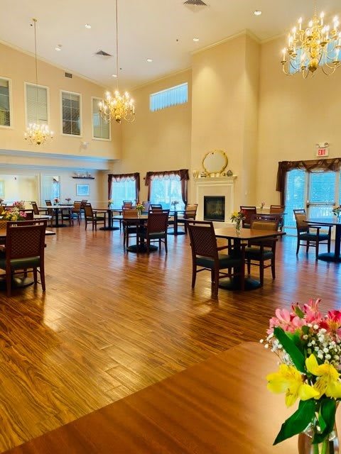 Spacious dining area with elegant chandeliers and wooden flooring.