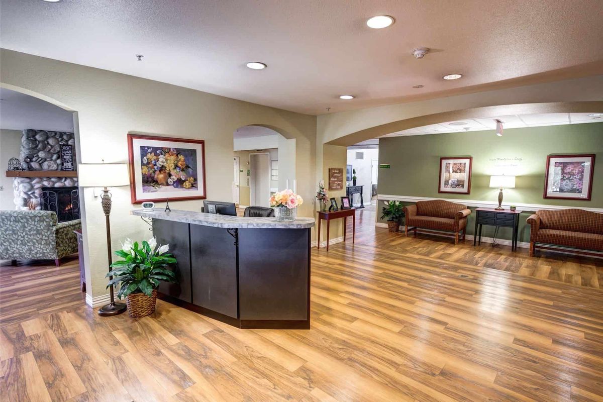 A modern reception area with wooden flooring and a welcoming desk.
