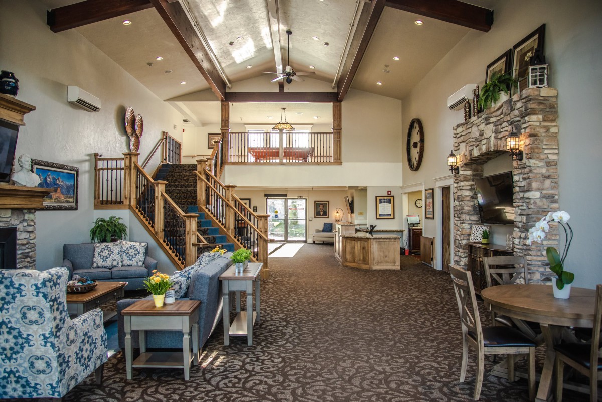 A spacious living area with a modern design featuring a staircase and fireplace.