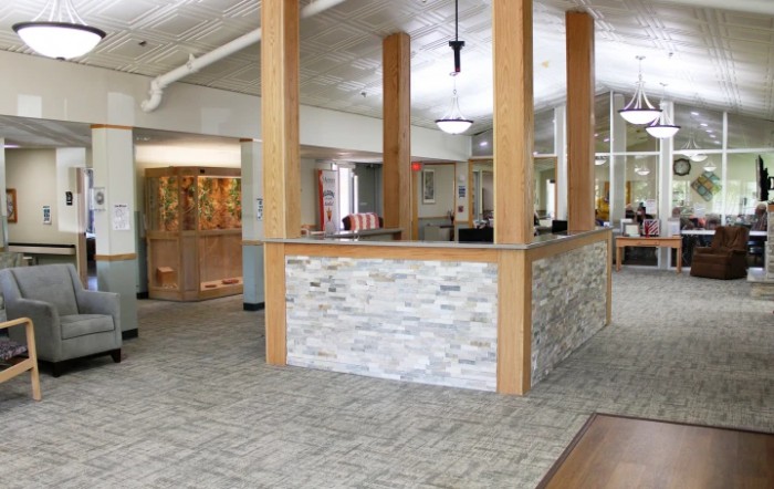 A modern office reception area with a stone wall and open layout.