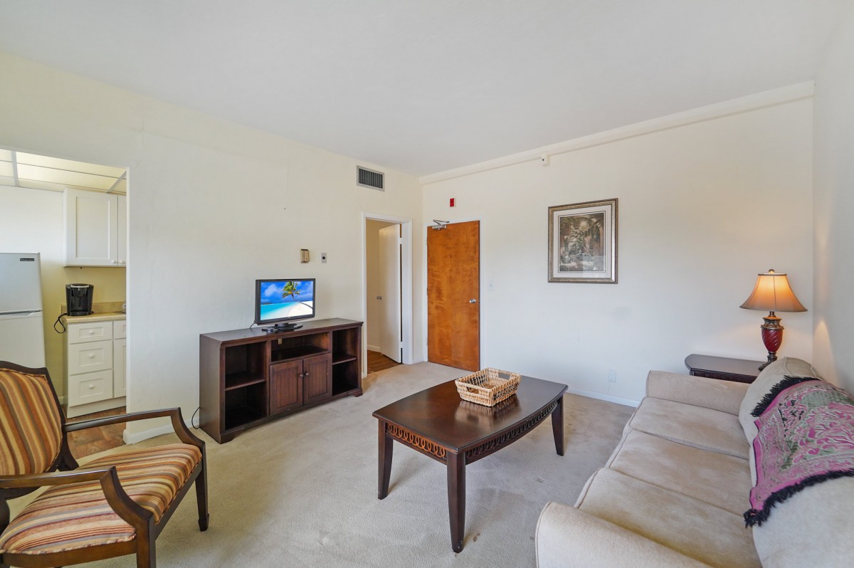 A cozy living room with a sofa, coffee table, and television.