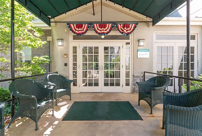 A welcoming entrance with patio seating and patriotic decorations.