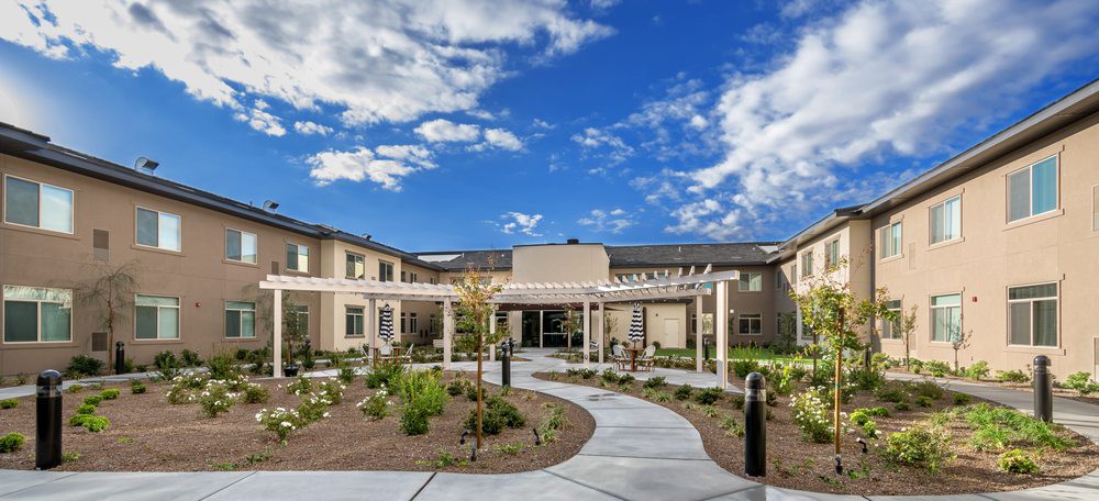A modern building with a landscaped garden and clear blue sky.