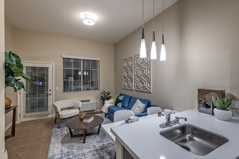 Modern living room with a cozy atmosphere, featuring a blue sofa and pendant lighting.