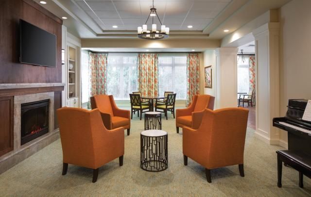 A cozy lounge area with orange chairs and modern decor.