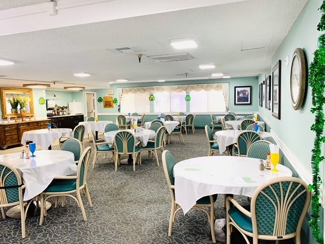 A spacious dining area with neatly arranged tables and chairs in a well-lit restaurant.