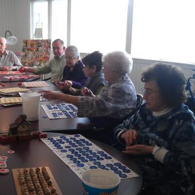 A group of seniors engaging in a crafting activity together at a table.