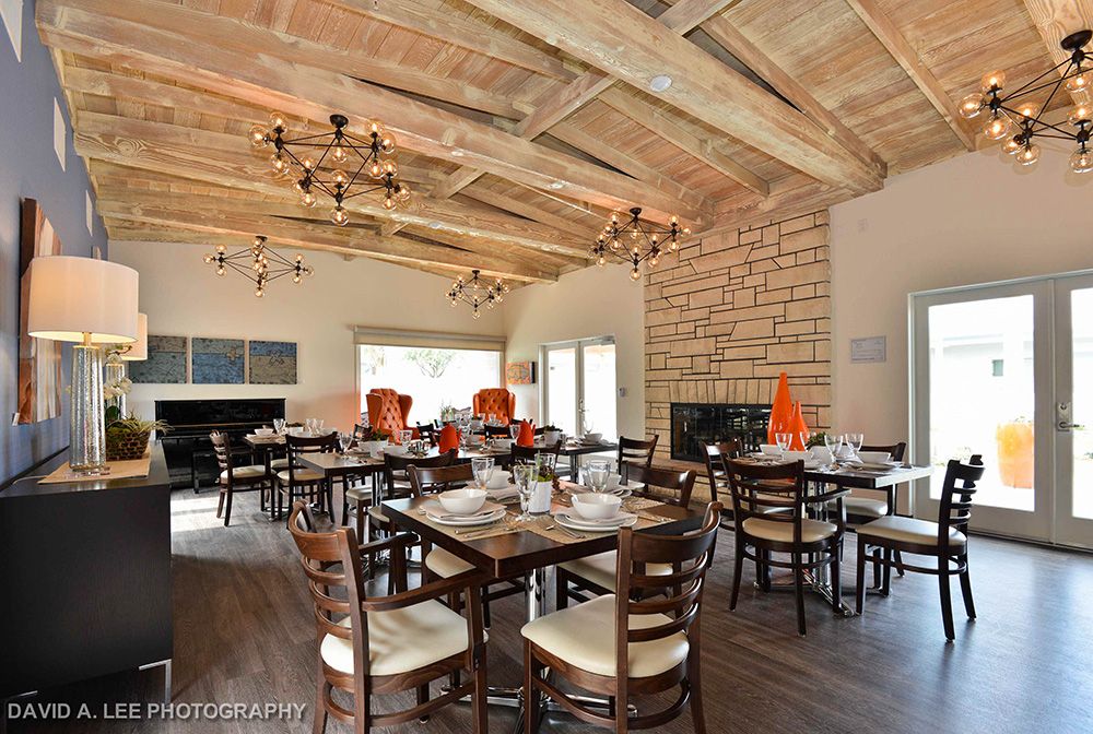 A cozy restaurant dining area with wooden ceilings and elegant chandeliers.